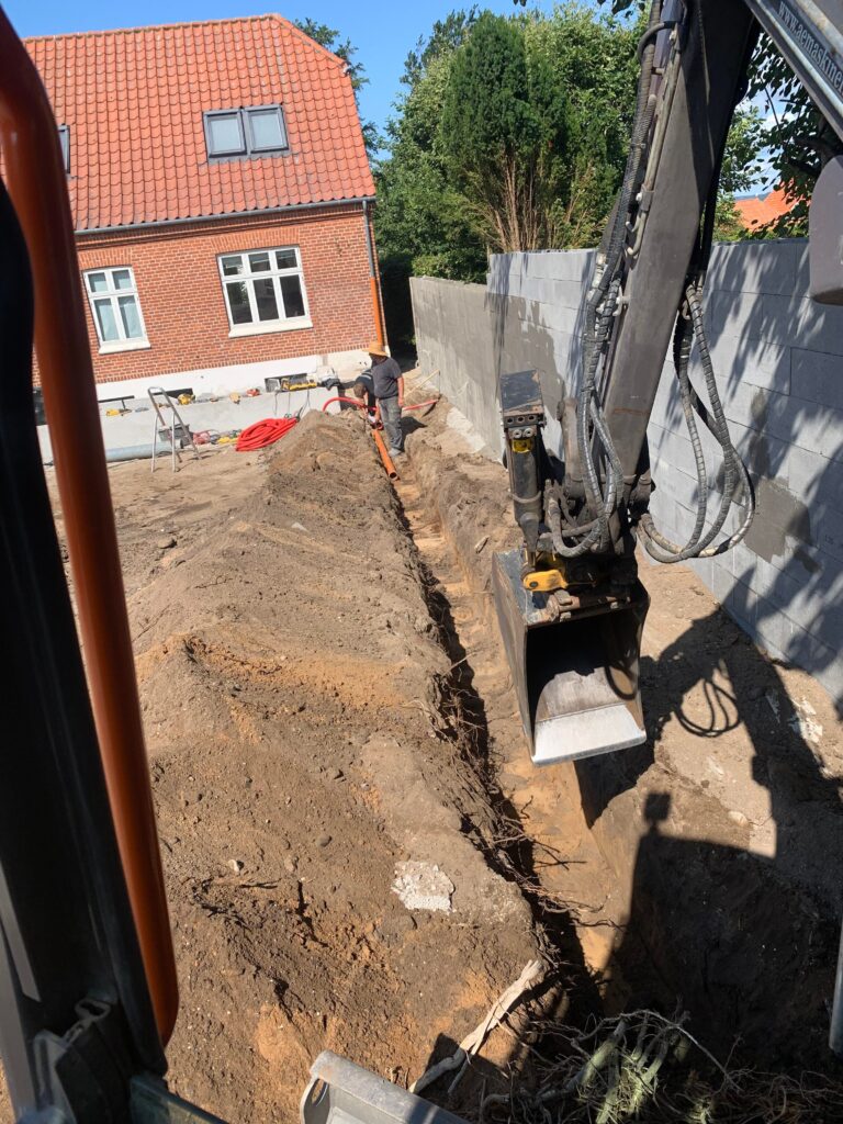 ved at anlægge en beton sokkel, og har anlagt en stor betonmur over imod naboen